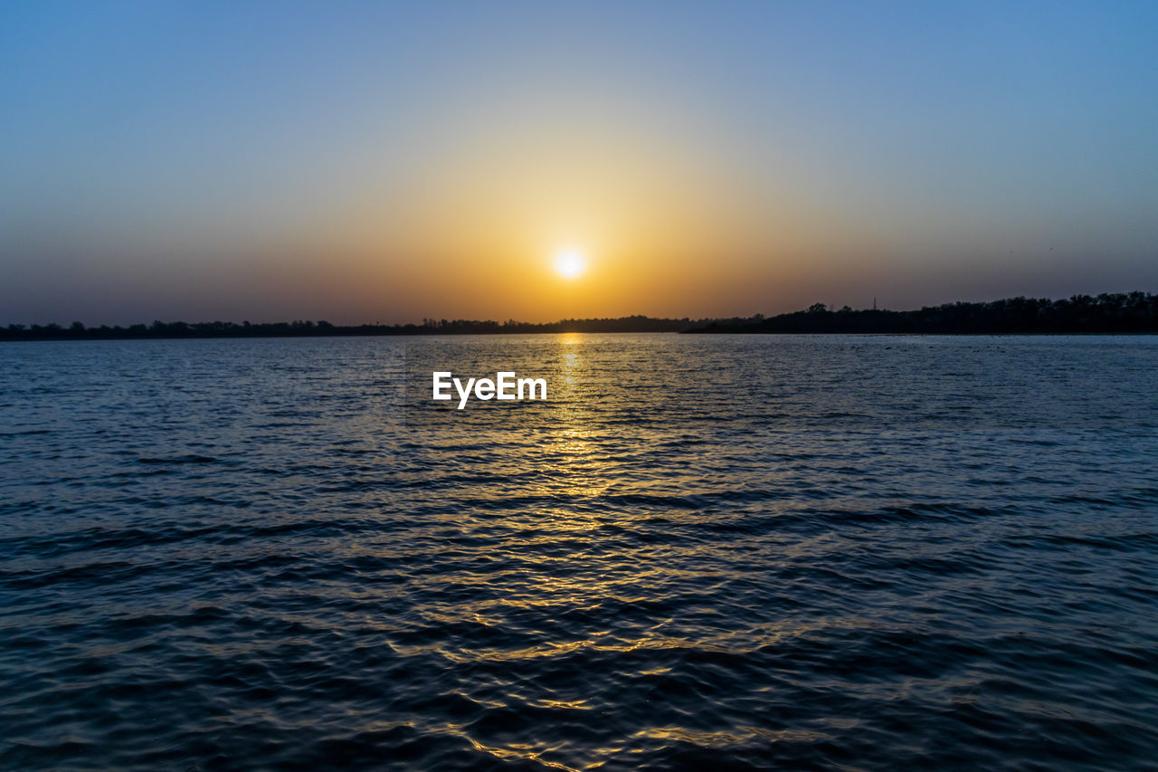 SCENIC VIEW OF SEA AT SUNSET