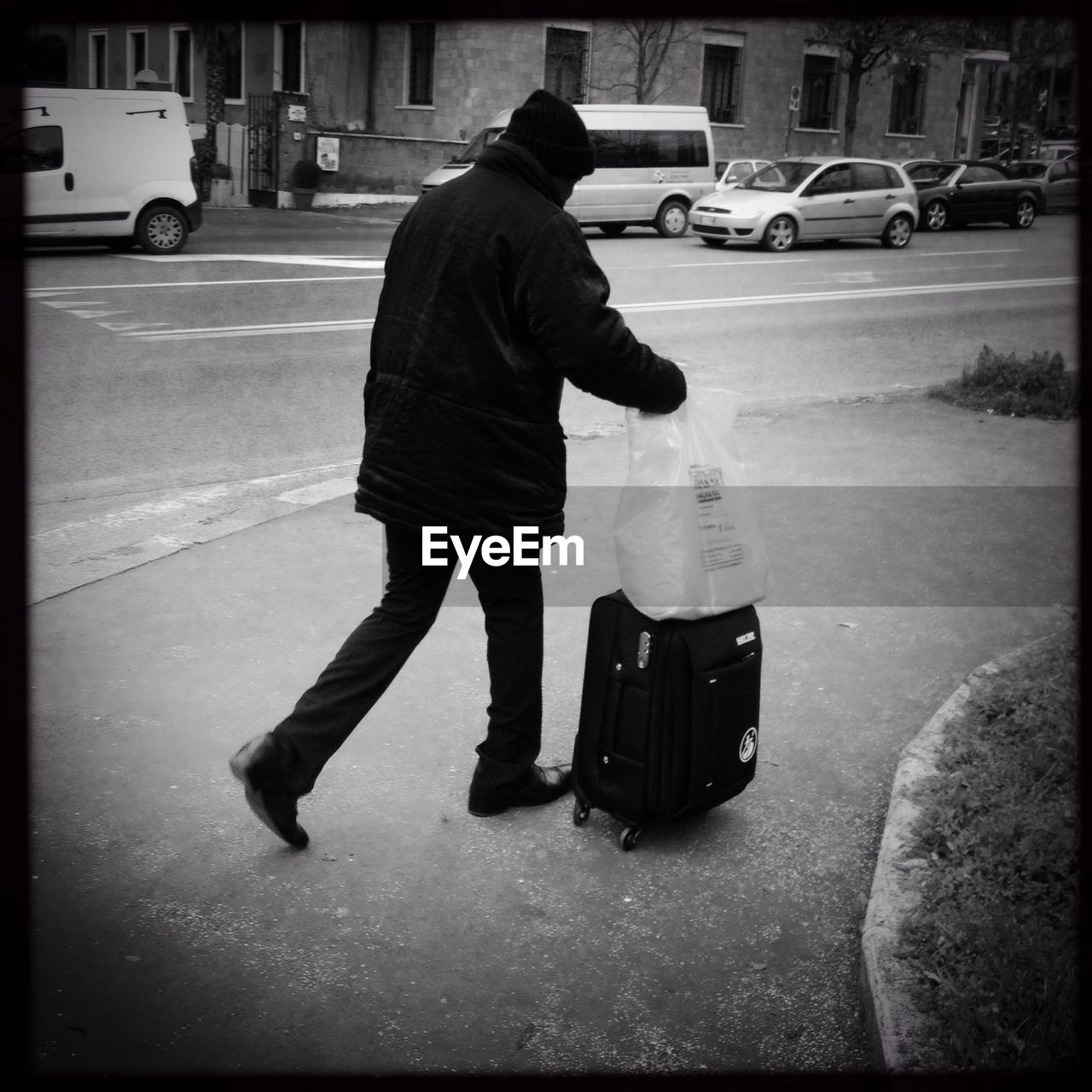 Full length of man carrying luggage on street