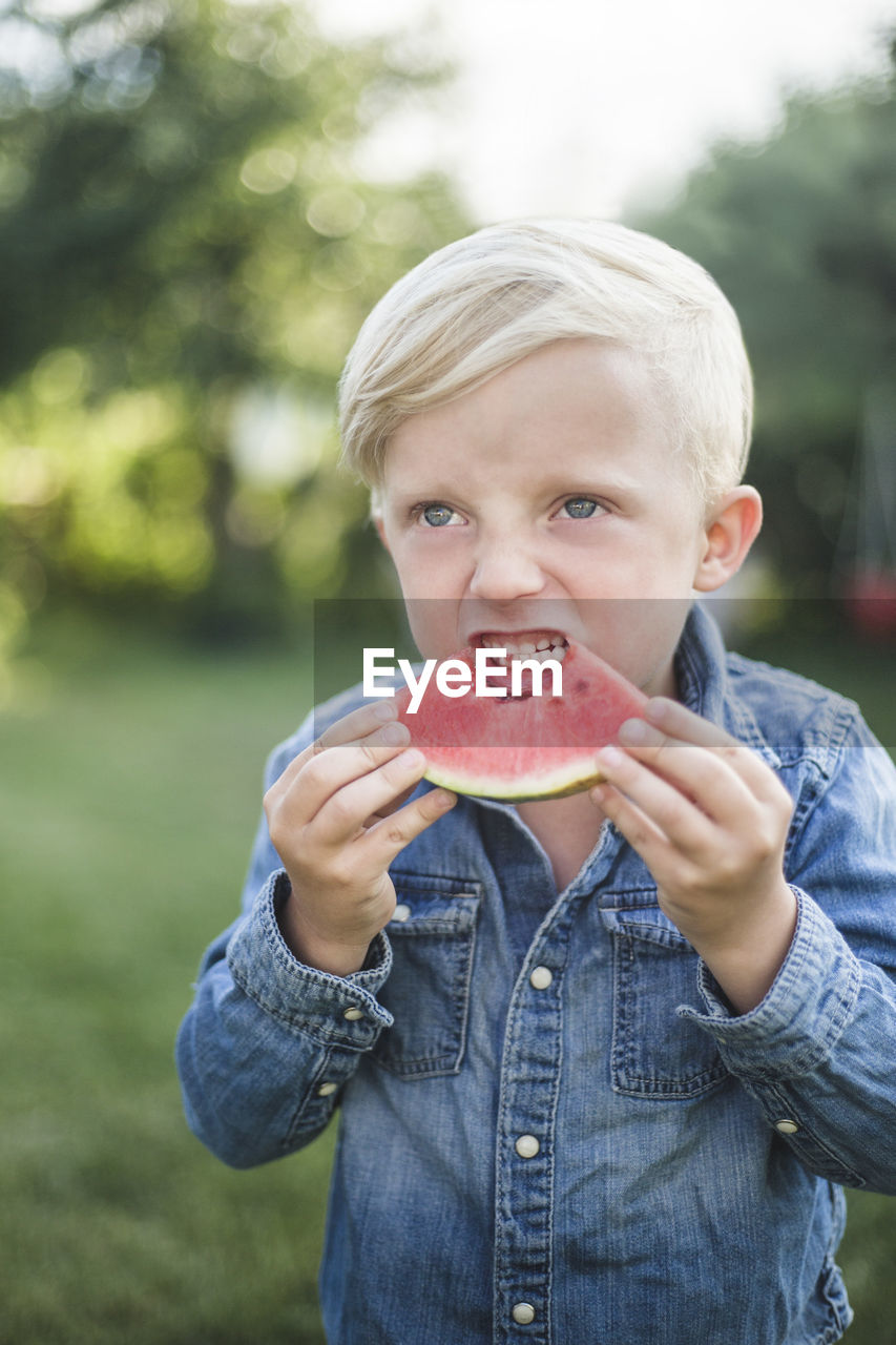 PORTRAIT OF BOY EATING APPLE