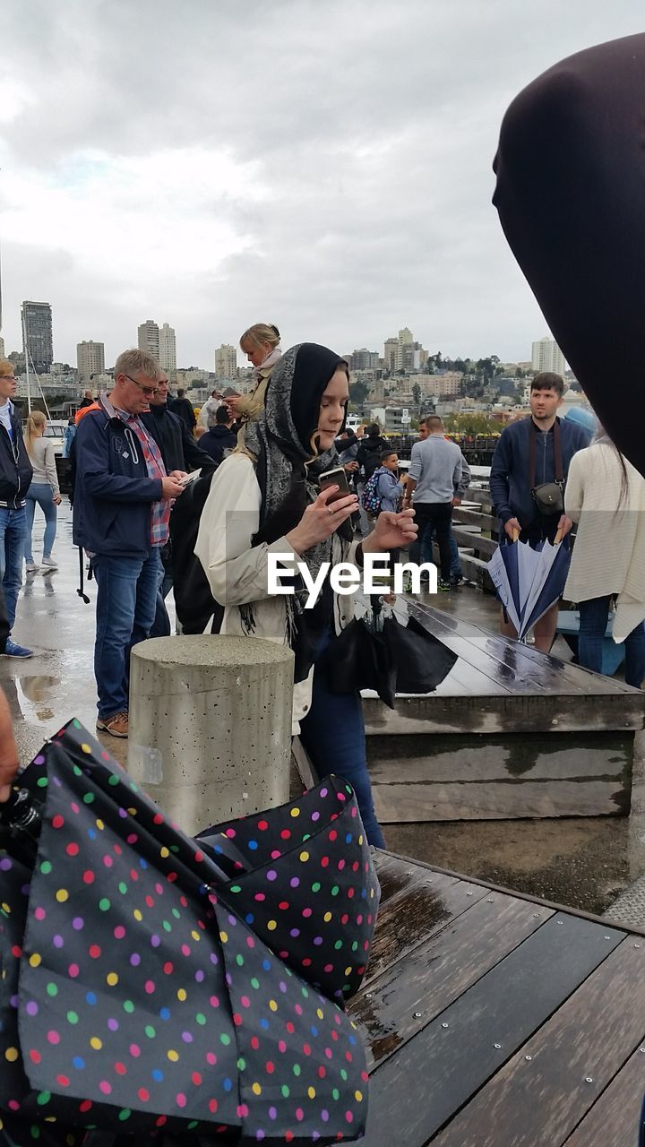 MIDSECTION OF WOMAN STANDING ON MOBILE PHONE