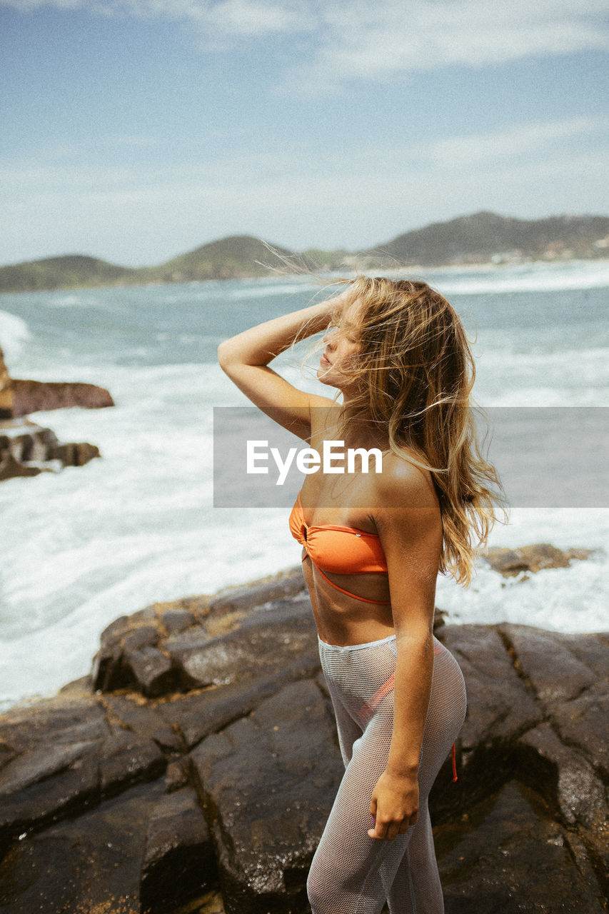Rear view of woman standing at beach