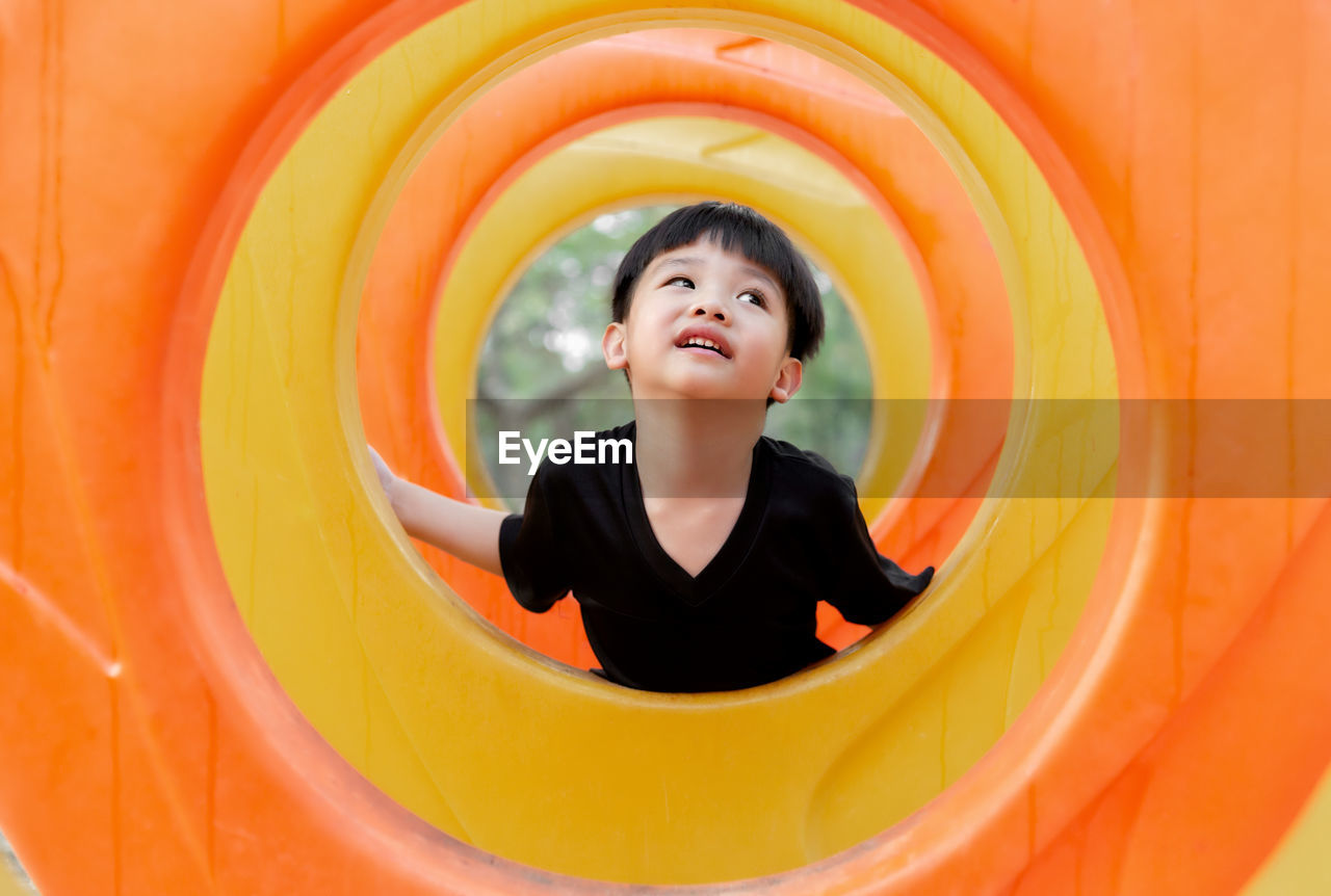 Cute boy looking away while playing at playground