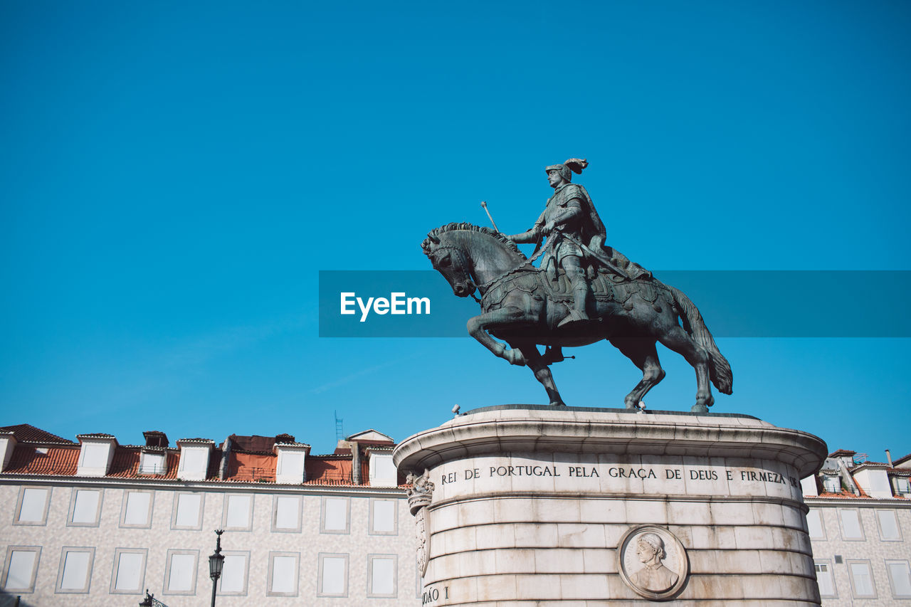 Low angle view of statue against blue sky