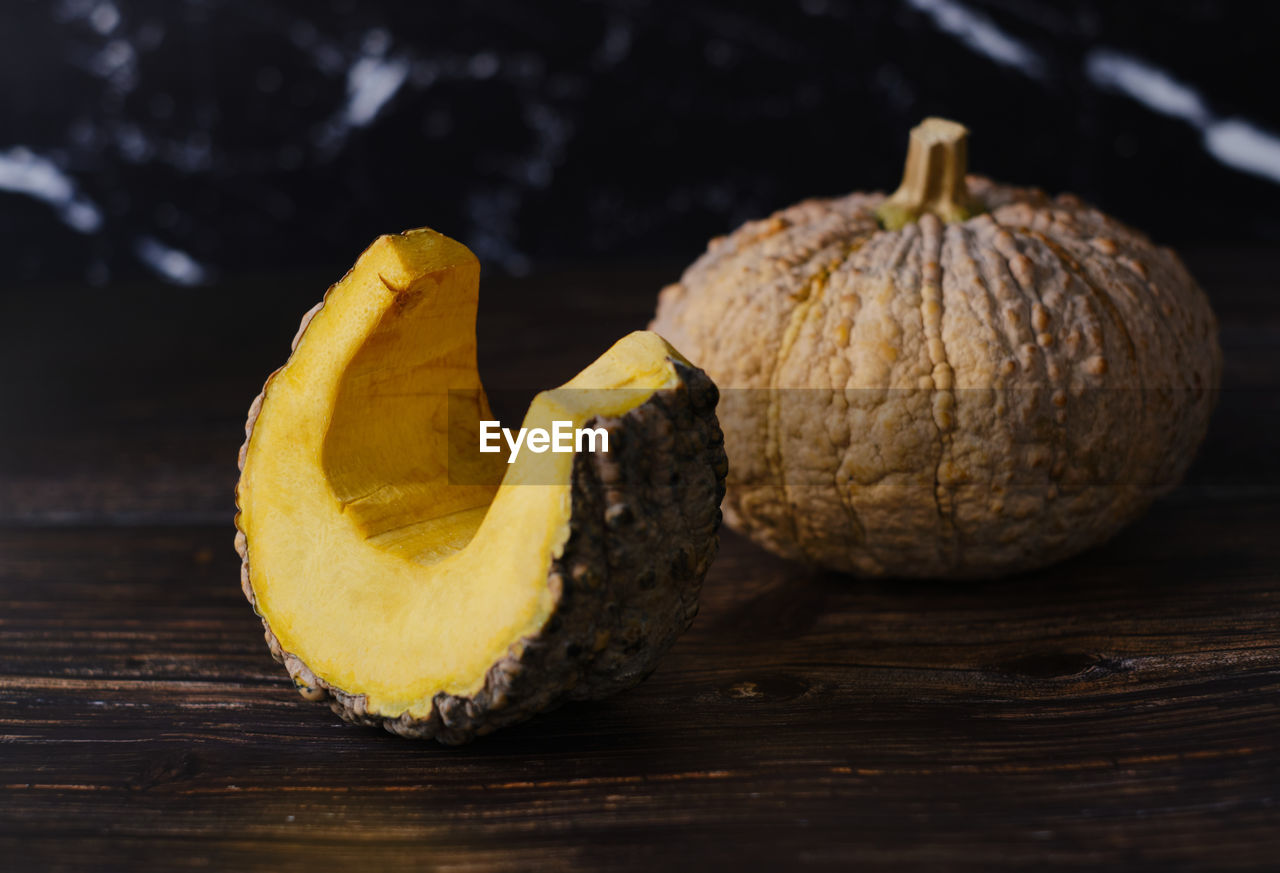 CLOSE-UP OF PUMPKINS ON WOOD