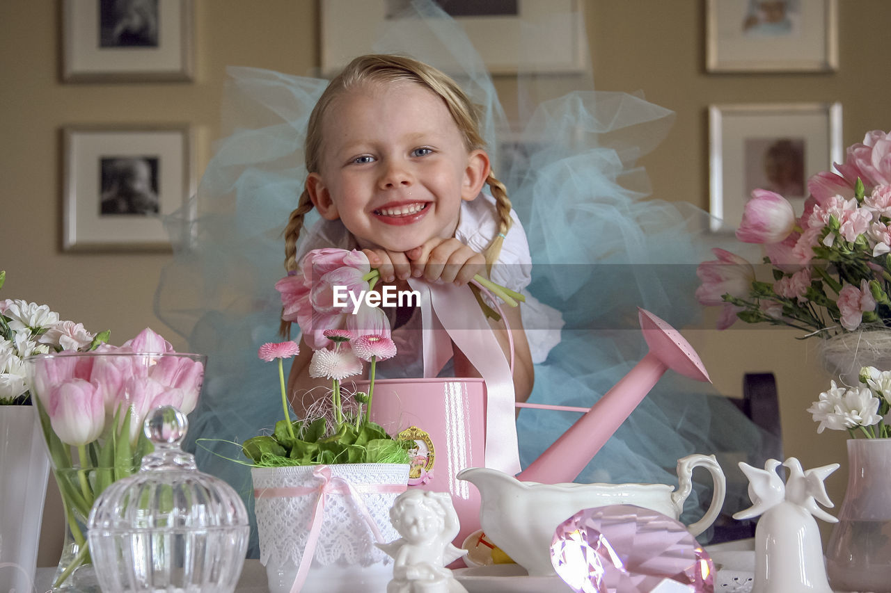 Portrait of little girl with objects on table