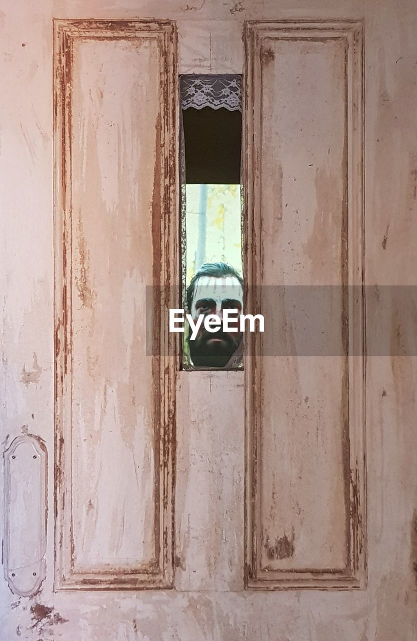 PORTRAIT OF MAN IN ABANDONED DOOR