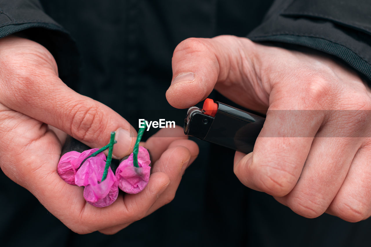 Close-up of man igniting firecracker outdoors