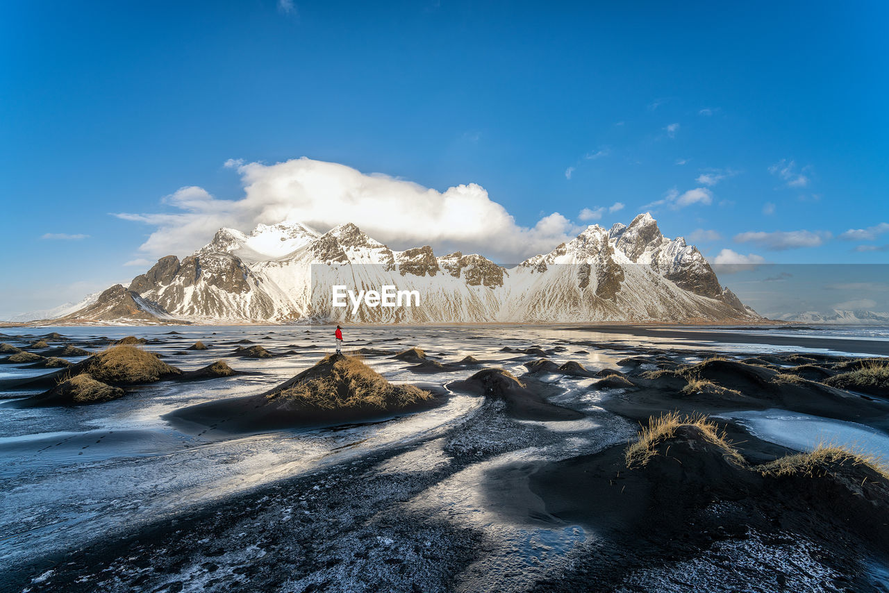 Scenic view of sea and snowcapped mountains against sky