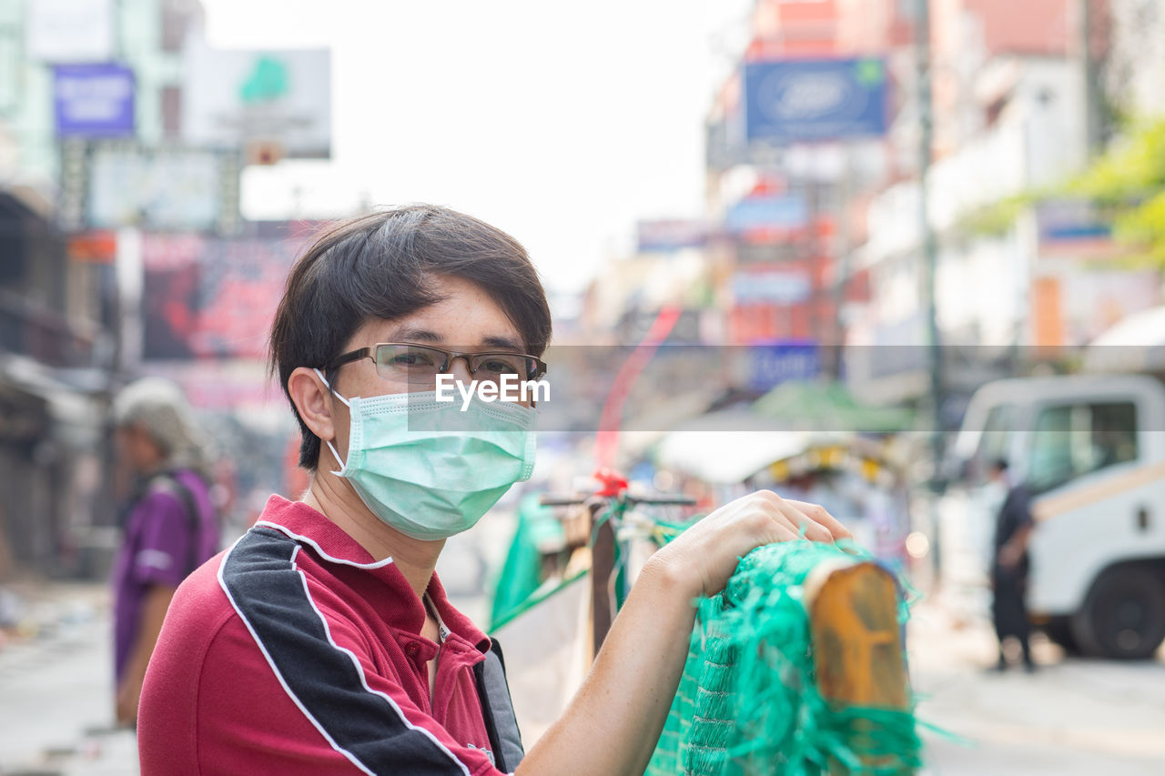 Portrait of young man wearing mask in city