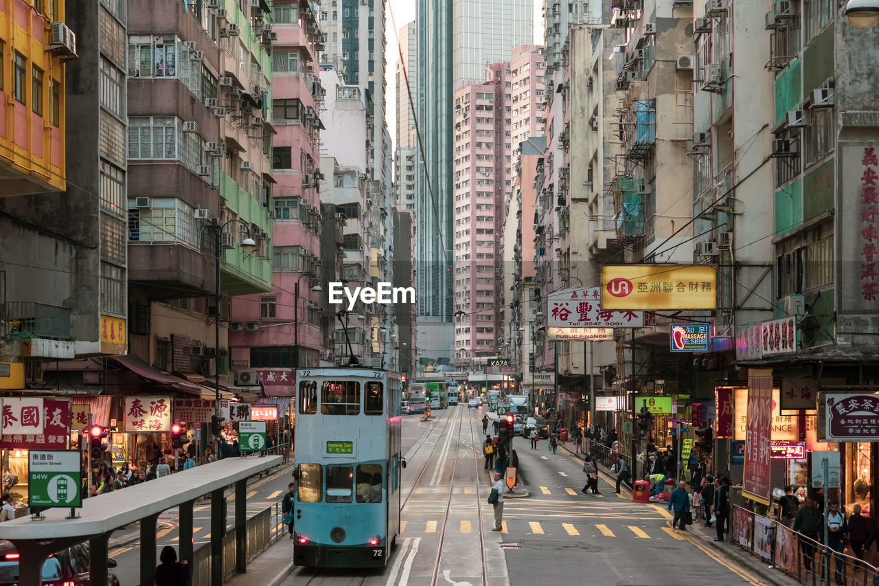 People walking on street amidst buildings in city