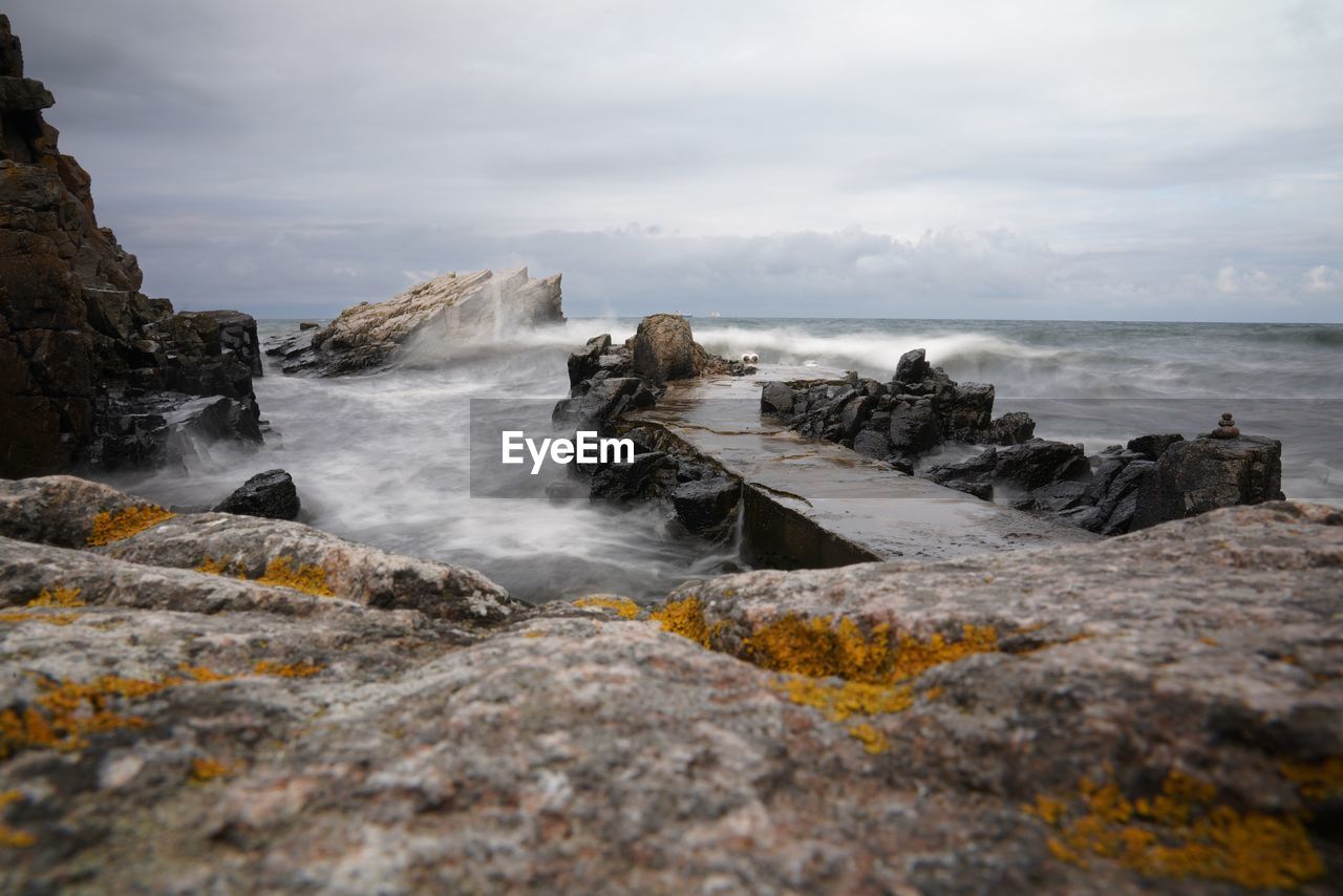 Rocks in sea against sky