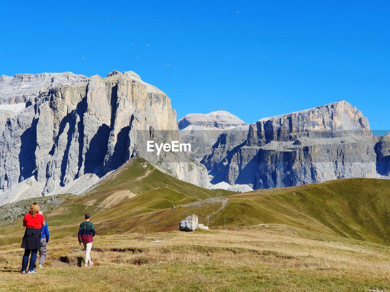 REAR VIEW OF PEOPLE ON MOUNTAIN AGAINST CLEAR SKY