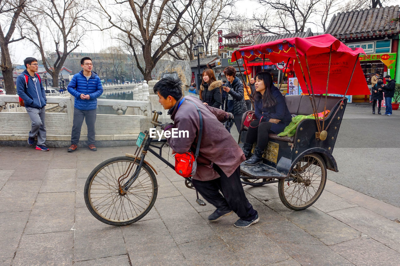 PEOPLE SITTING ON BICYCLE PARKED ON STREET