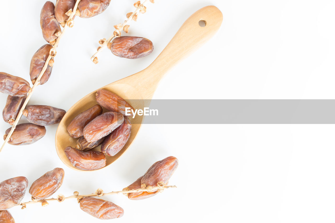 Directly above shot of nuts in wooden spoon on white background