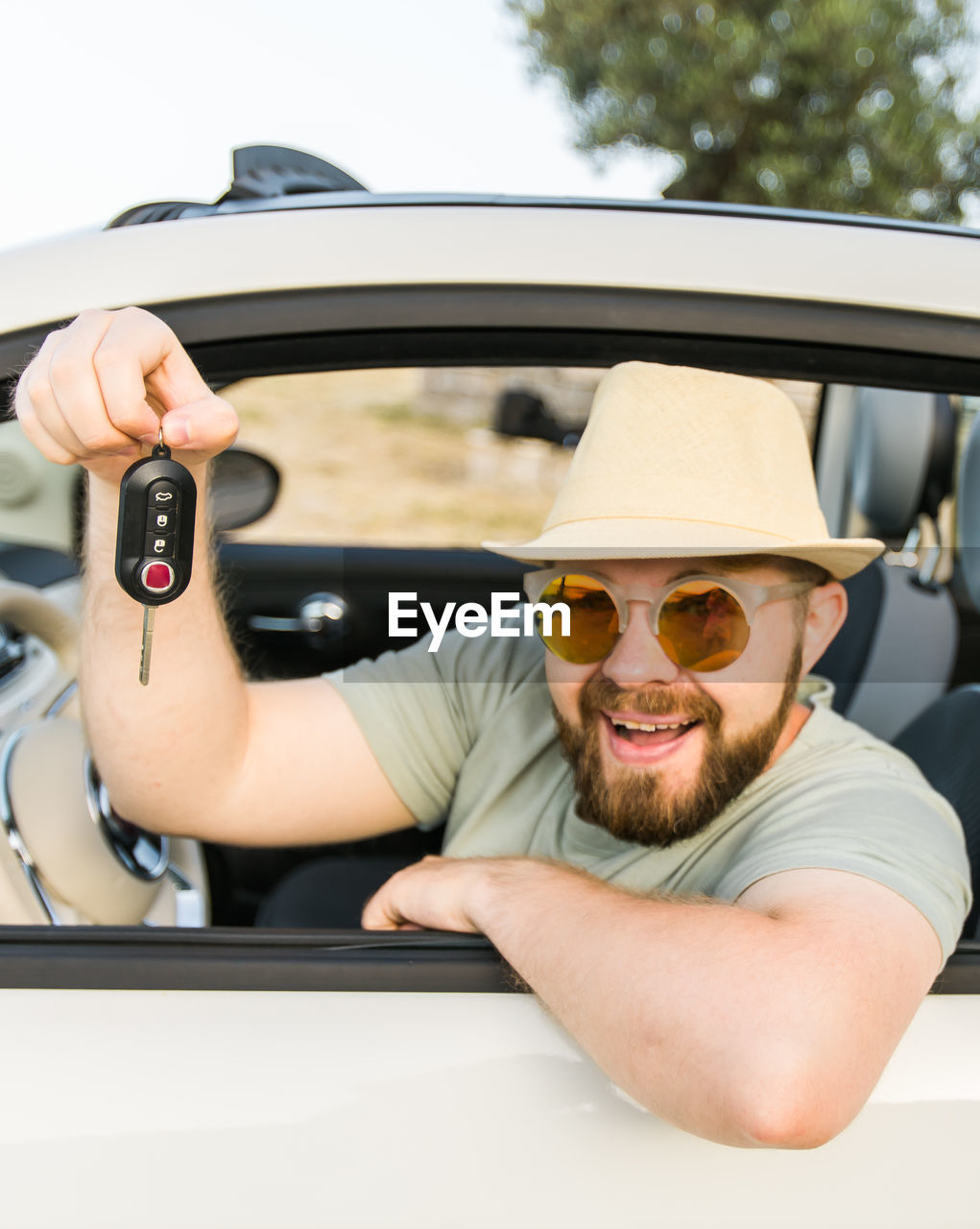 low angle view of young man using mobile phone while sitting in car