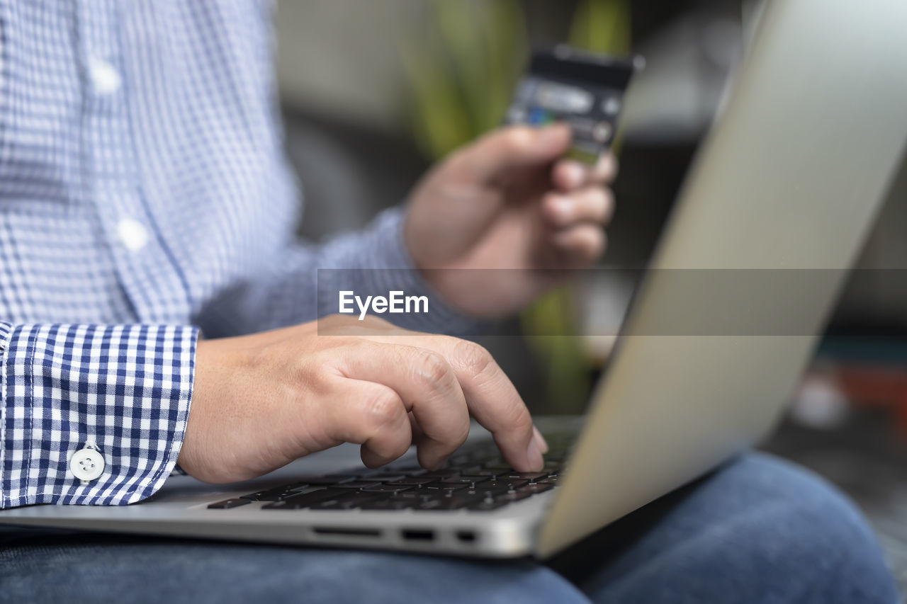 Midsection of man using laptop