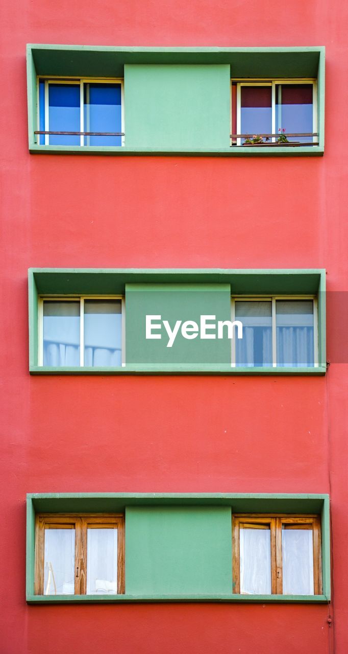 Close-up of green window in red house