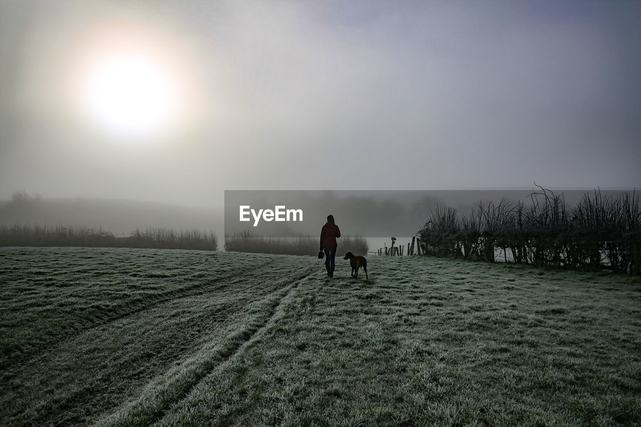 MEN WALKING ON SNOW COVERED LAND