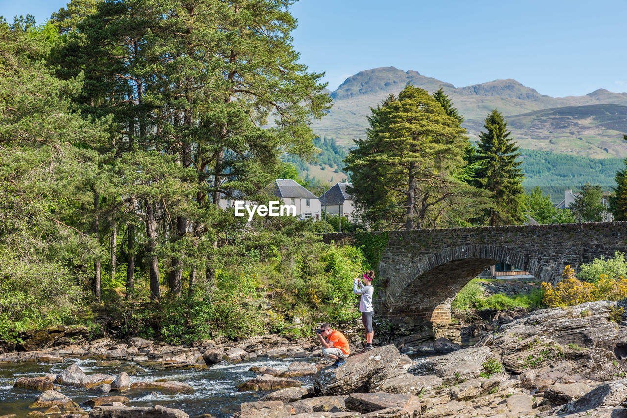 A couple of tourists taking pictures of falls of dochart