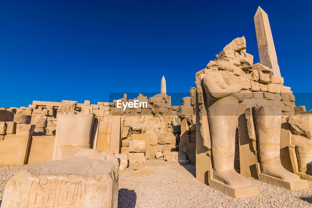 Statue and ruins with hieroglyphics in the famous karnak temple in luxor, egypt. 