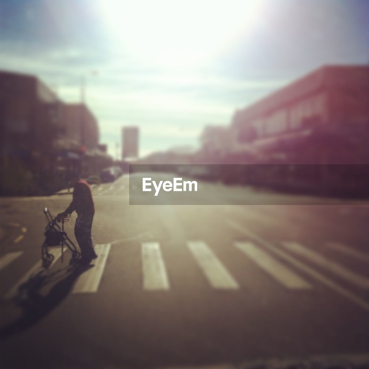 Man with wheeled walker on zebra crossing