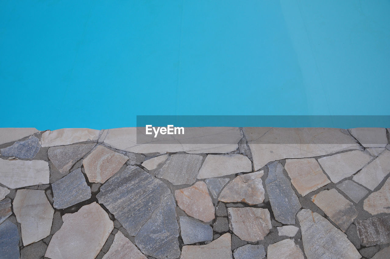 STONE WALL WITH FOOTPATH AGAINST CLEAR BLUE SKY