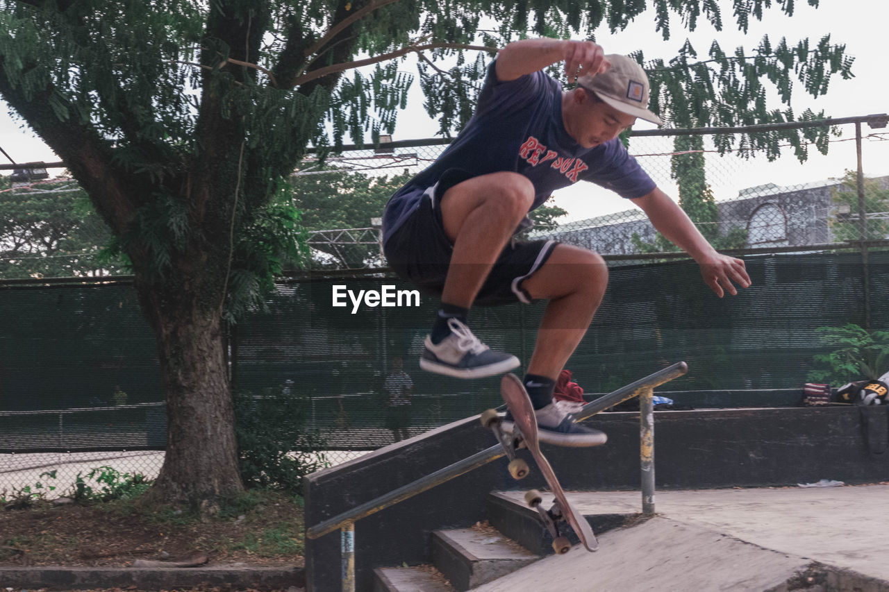 FULL LENGTH OF YOUNG MAN JUMPING OUTDOORS