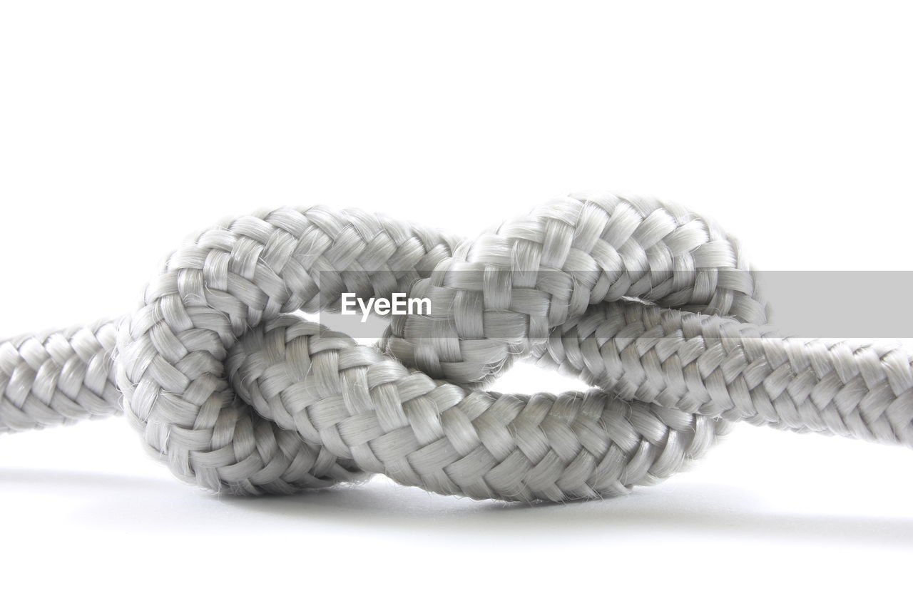 Close-up of rope tied against white background