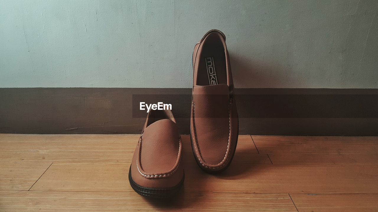 Close-up of brown shoes on hardwood floor at home