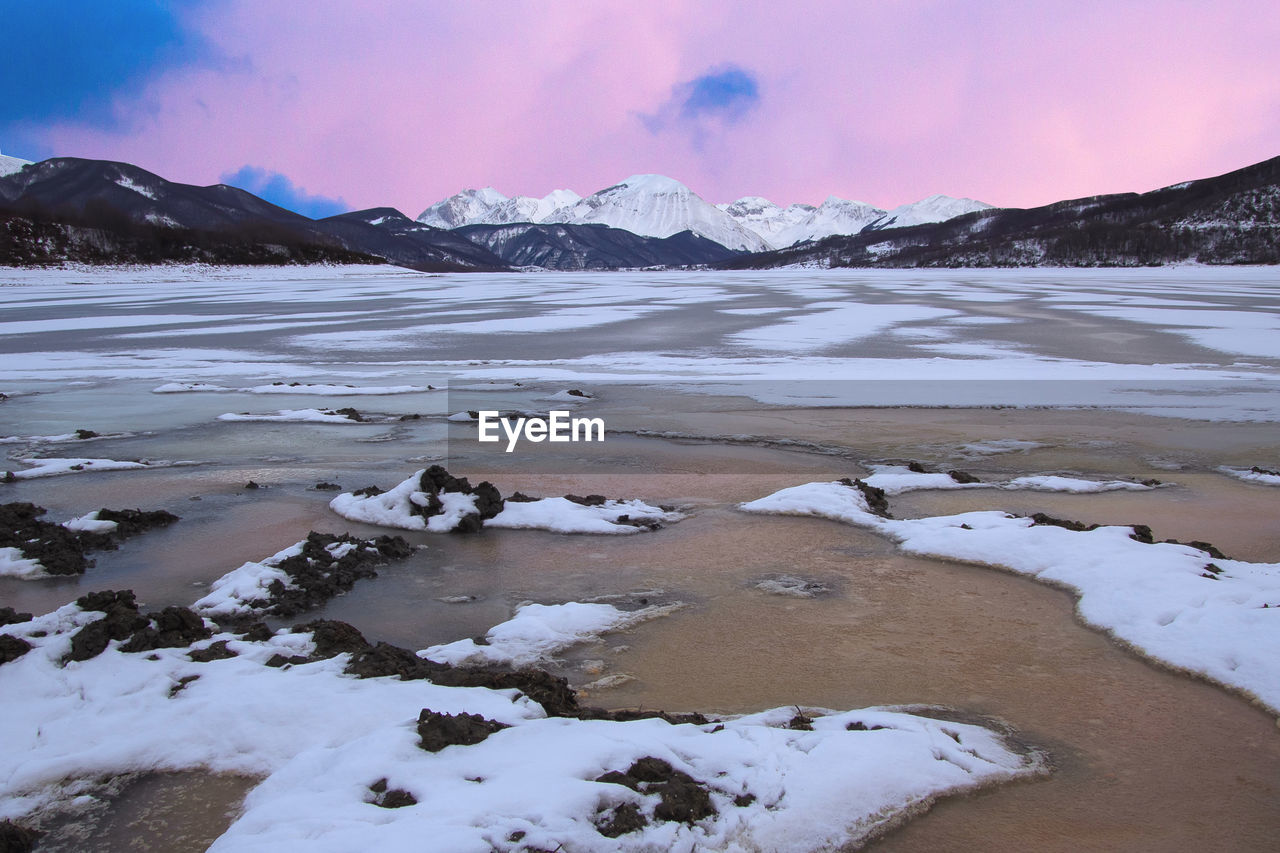 Winter view of lake campotosto and in the background the mountains area of gran sasso italy