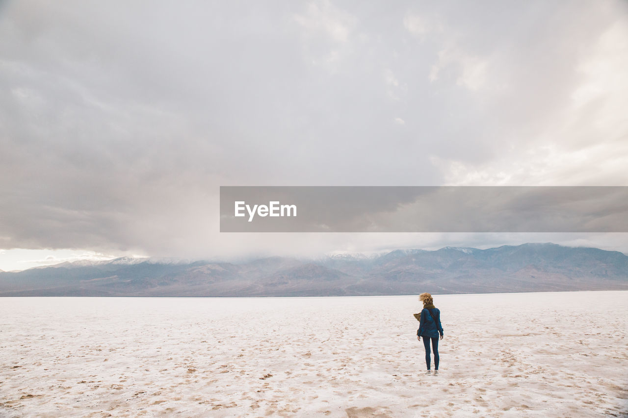 Full length of woman standing on landscape against sky