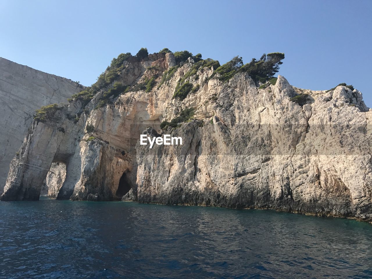 Scenic view of sea and mountains against clear sky