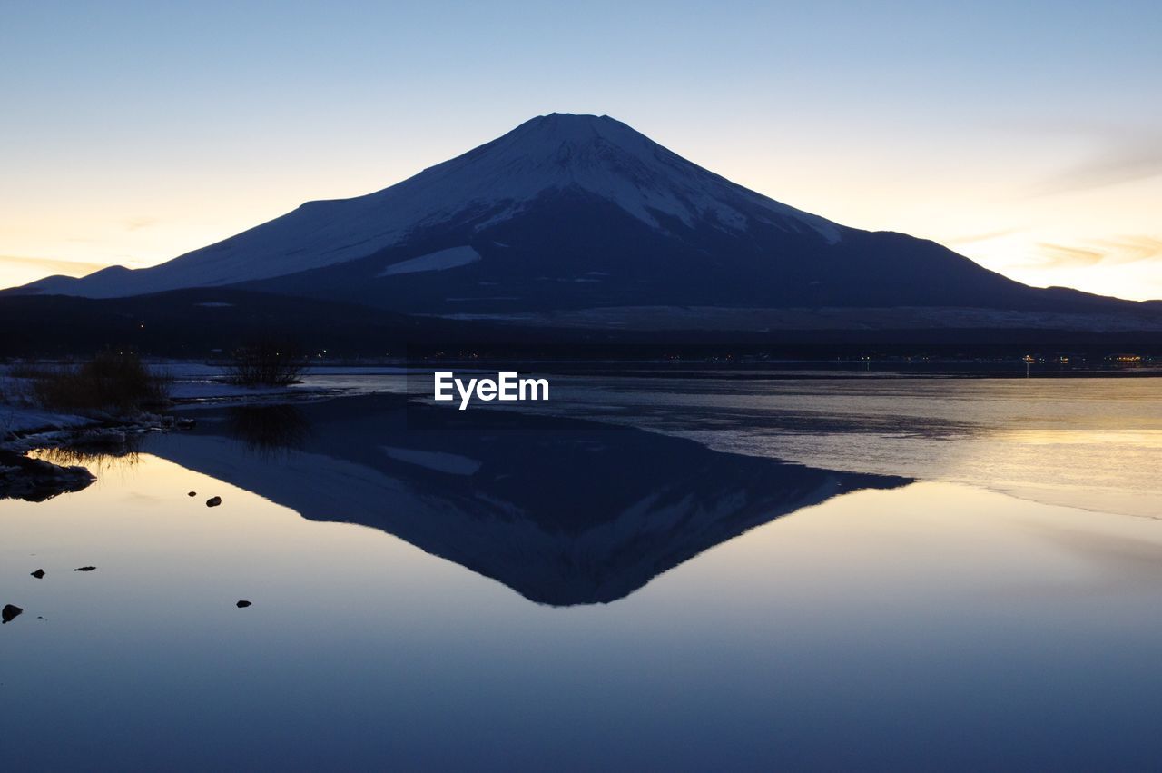 Reflection of mountain on lake at sunset