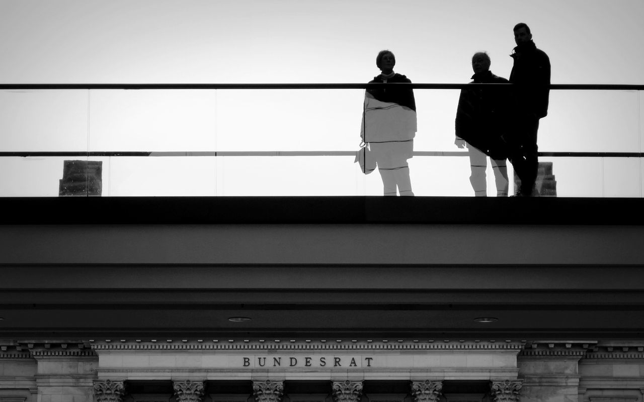 LOW ANGLE VIEW OF WOMAN WALKING IN CITY