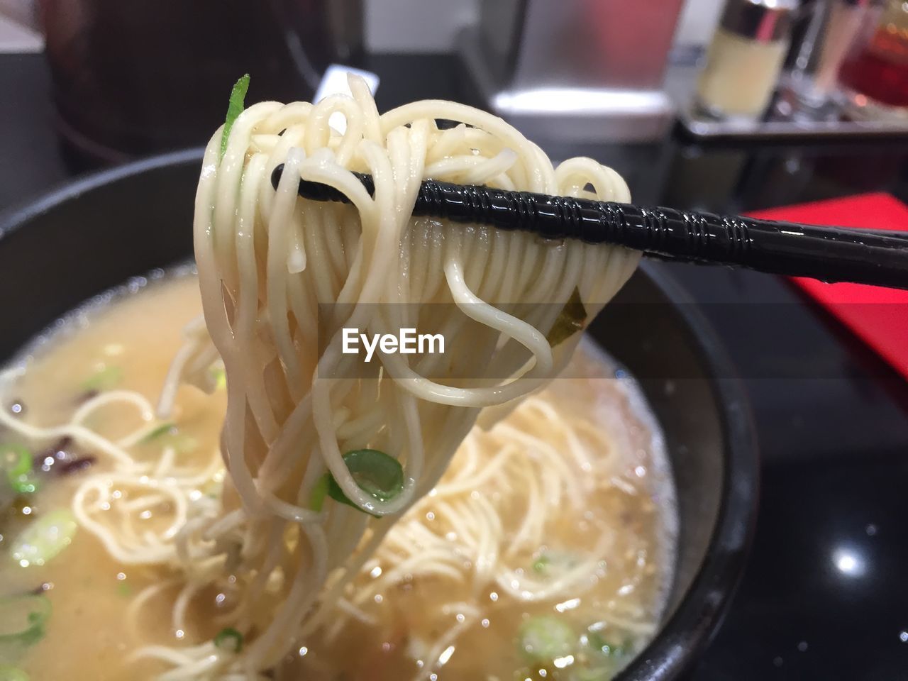 Close-up of chopsticks holding ramen noodles