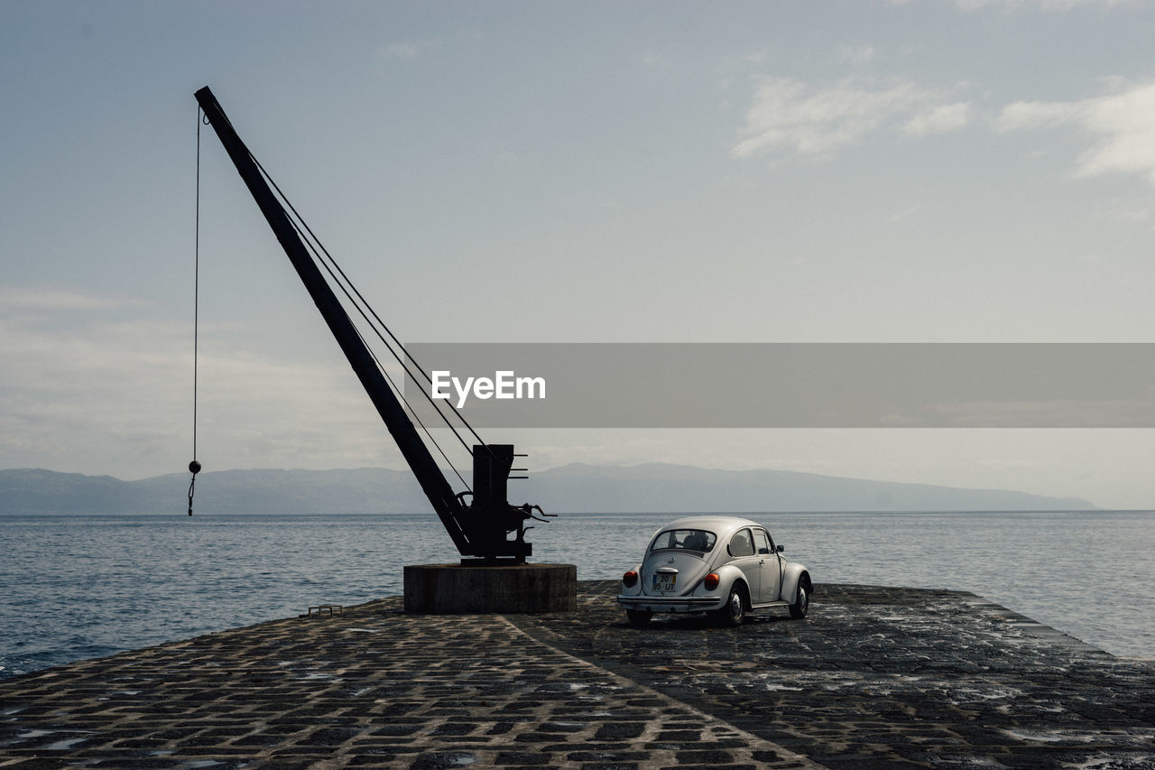 Volkswagon beetle on a pier by the ocean