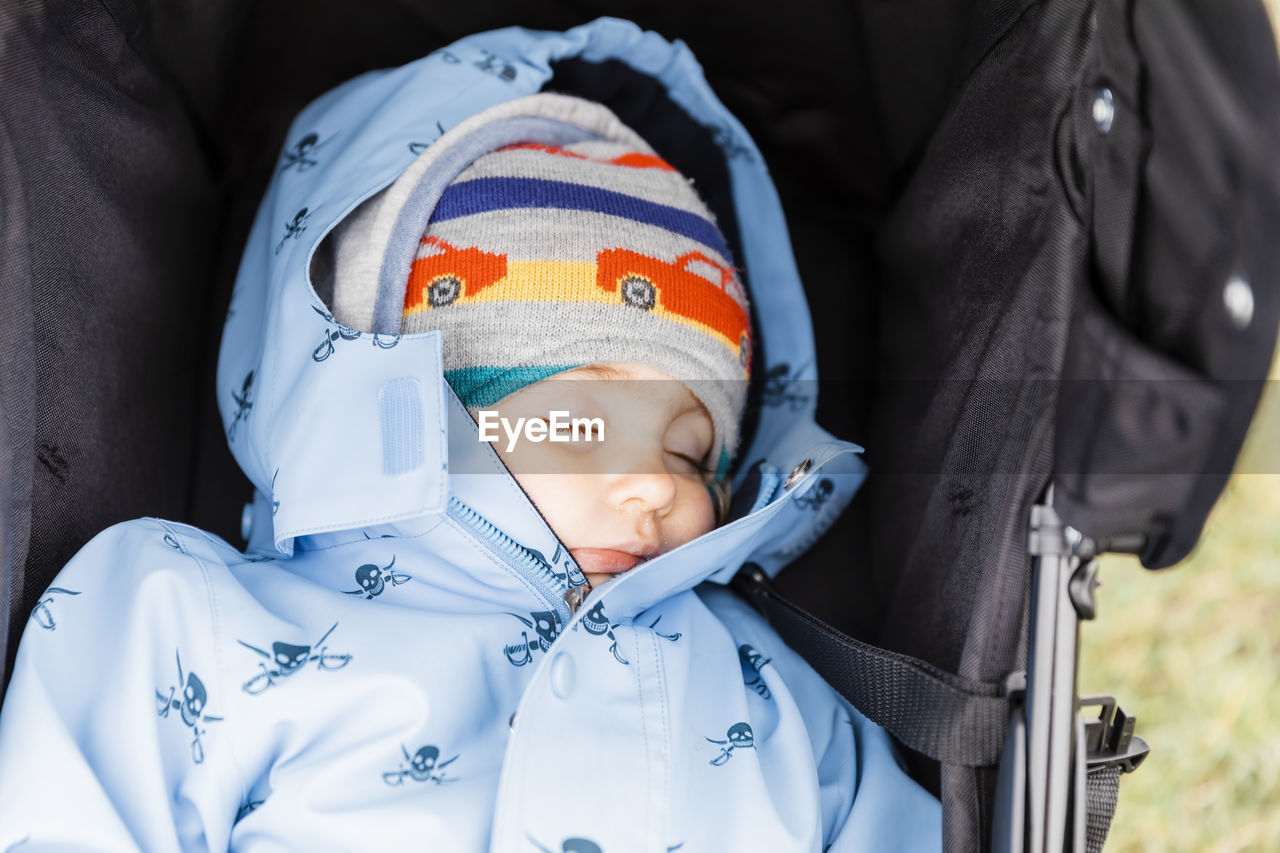 High angle view of cute girl wearing warm clothing while lying in baby stroller