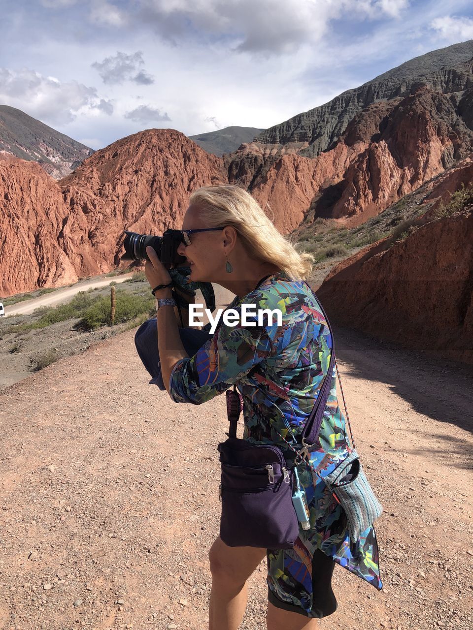 SIDE VIEW OF WOMAN STANDING ON MOUNTAIN