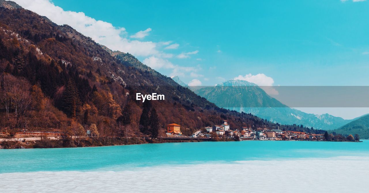 Scenic view of sea by mountains against sky