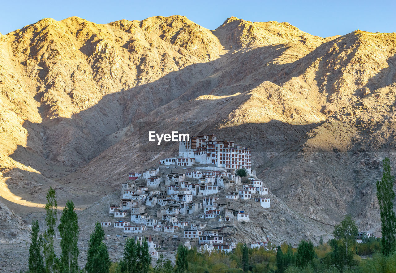 Scenic view of mountain against buildings