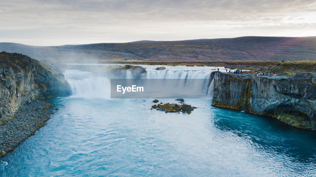 Scenic view of waterfall against sky