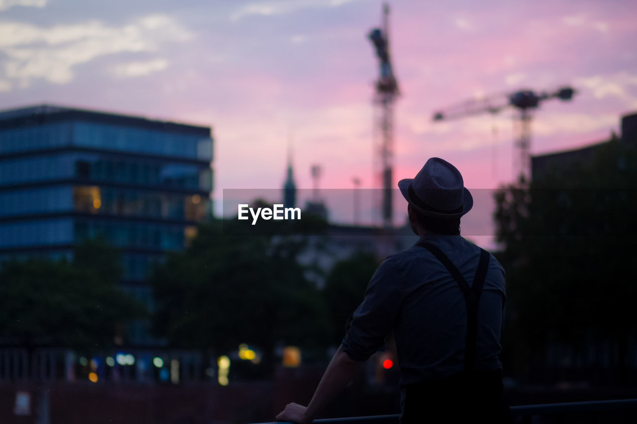 Rear view of man standing against sky during sunset
