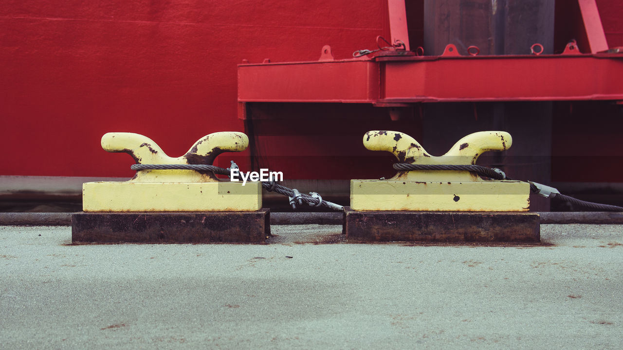 CLOSE-UP OF YELLOW BIRD ON RED METAL