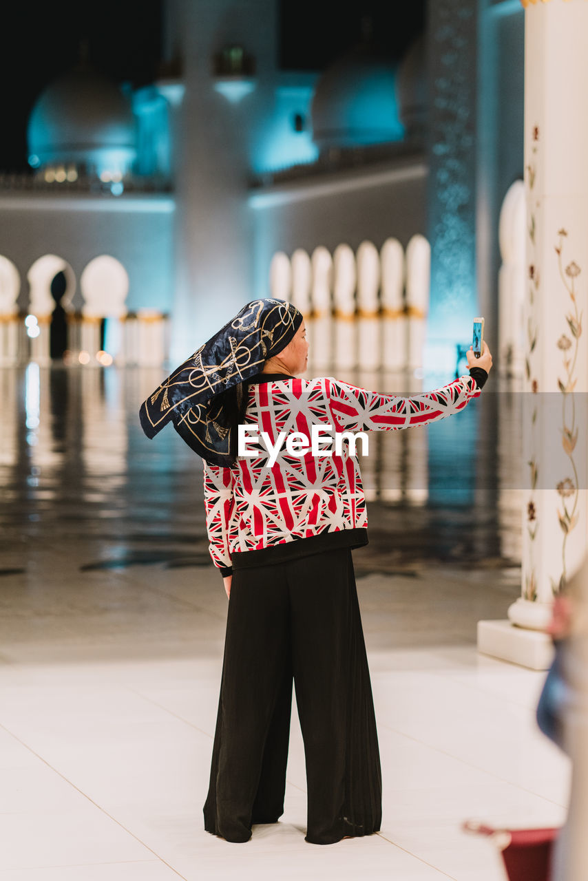 Woman taking selfie while standing on floor