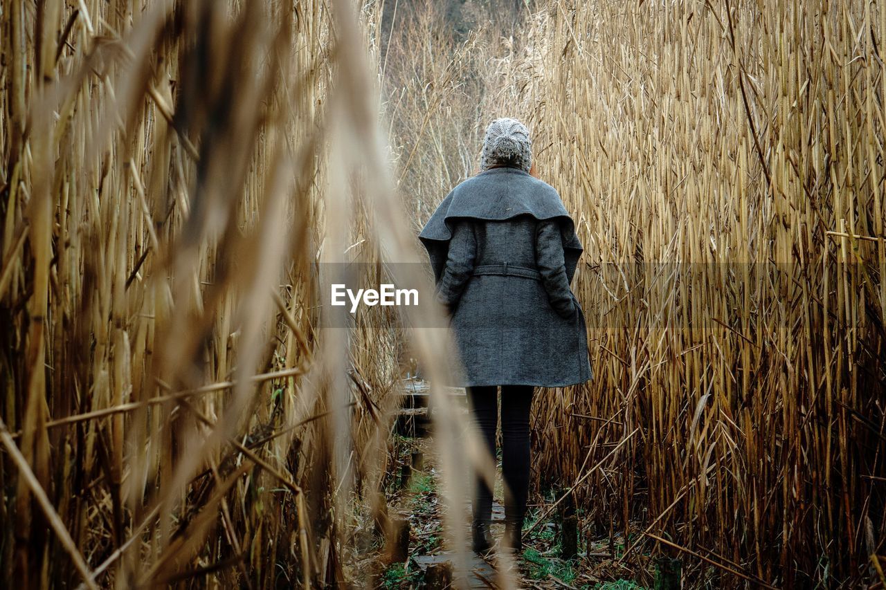 Rear view of woman walking on field