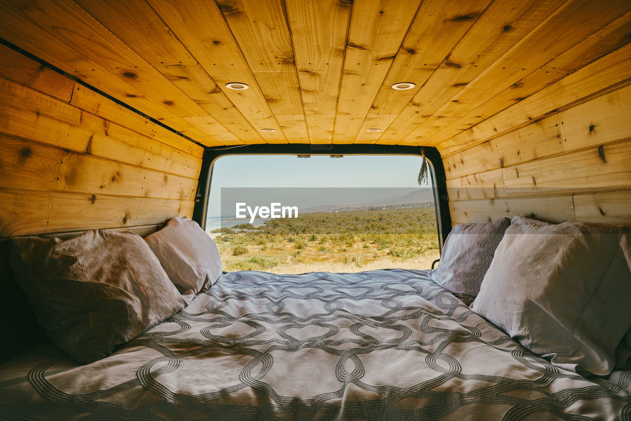 View of ocean during day from bed of camper van in baja, mexico.