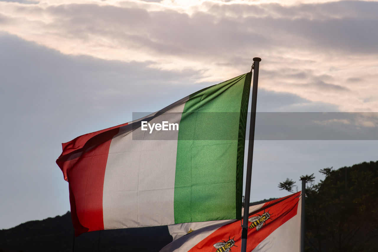 LOW ANGLE VIEW OF FLAGS FLAG ON POLE AGAINST SKY