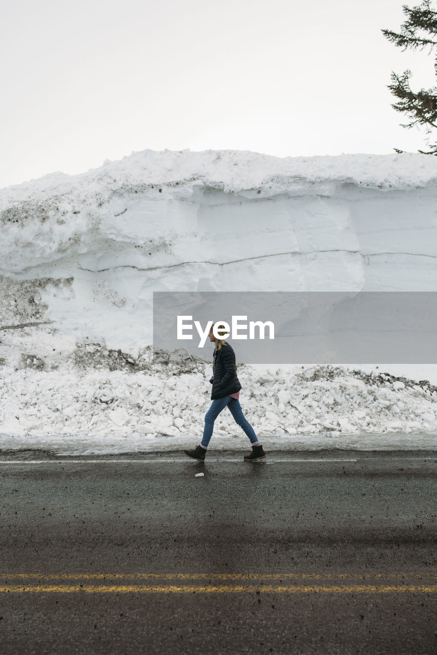 FULL LENGTH OF MAN STANDING ON SNOW AGAINST MOUNTAIN