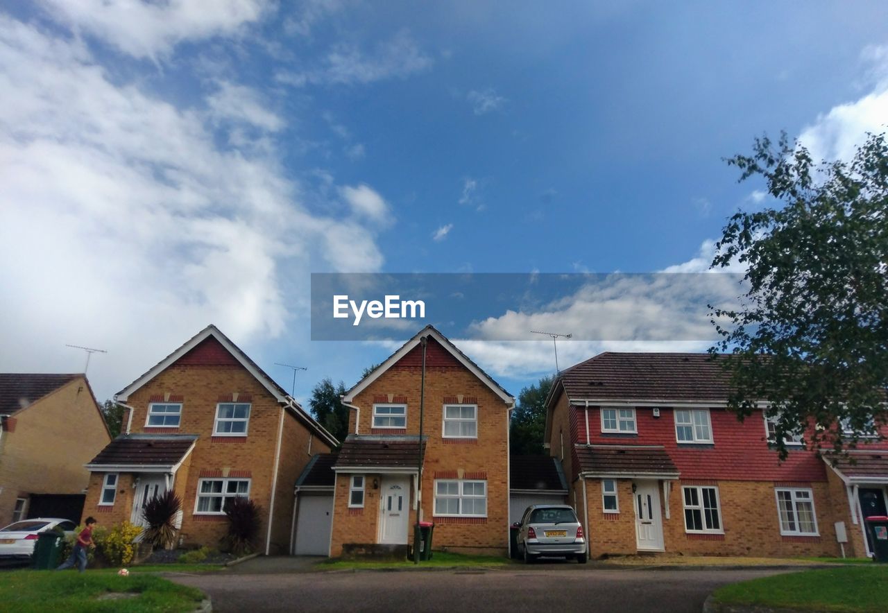 HOUSES BY TREE AGAINST SKY