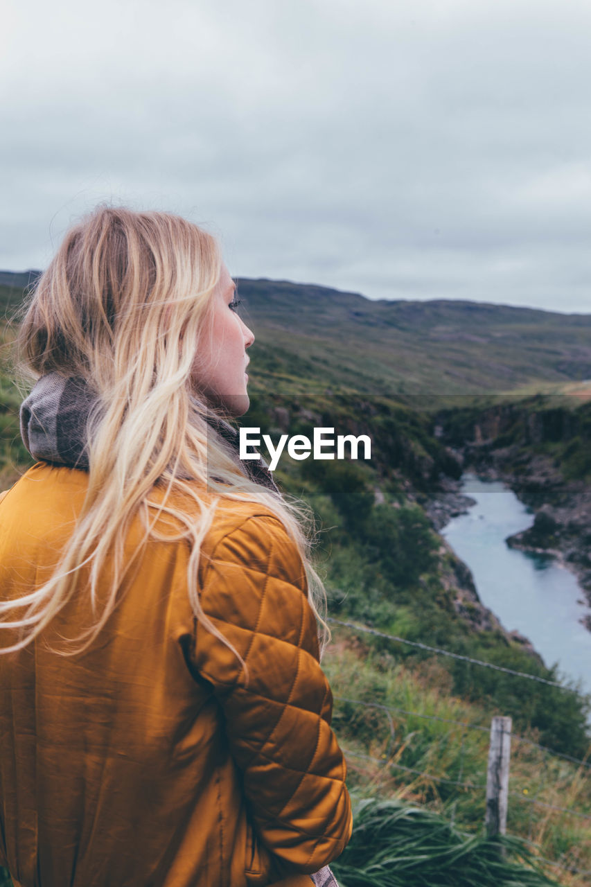 Thoughtful beautiful woman looking at view against sky